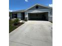 Home with white garage door and driveway at 2300 Crossandra St, Mascotte, FL 34753