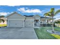 Two-car garage, gray siding, and a welcoming front porch at 241 Walkers Point Dr, Auburndale, FL 33823