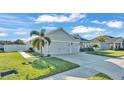 Two-car garage, gray siding, and spacious driveway at 241 Walkers Point Dr, Auburndale, FL 33823
