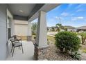 Relaxing front porch with stone columns and seating area at 416 Monticelli Dr, Haines City, FL 33844