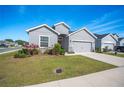 Single-story house with gray siding, red door, and attached garage at 4340 Reding Way, Lakeland, FL 33813