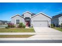Gray house with red door, two-car garage, and landscaped lawn at 4340 Reding Way, Lakeland, FL 33813