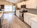Modern kitchen with white cabinets, stainless steel appliances, and an island at 731 Lake Clark Ct, Lakeland, FL 33813