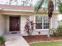 Home features a dark brown front door and lush landscaping at 8052 Sugar Pine Blvd, Lakeland, FL 33810