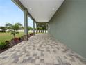Covered back patio with paver flooring and access to yard at 161 Laynewade Rd, Polk City, FL 33868