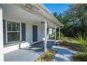 Inviting front porch with gray columns and a white brick exterior at 2226 Cordova N Cir, Lakeland, FL 33801