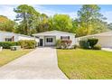 White single wide manufactured home with carport and landscaping in a wooded area at 32334 Oak Park Dr, Leesburg, FL 34748