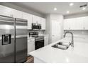 Well-equipped kitchen showcasing stainless steel appliances, white cabinets, and a functional island sink at 447 Ituna Cir, Winter Haven, FL 33881