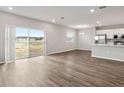 Spacious living area with wood-look flooring, large sliding doors, and a view of the kitchen at 447 Ituna Cir, Winter Haven, FL 33881