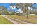 House sits on a large lot with a long driveway and mature trees surrounding at 5576 Albert Williams Rd, Mulberry, FL 33860