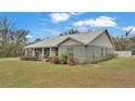 Gray house with metal roof, stone accents, and landscaping. Located on a spacious lot at 5576 Albert Williams Rd, Mulberry, FL 33860
