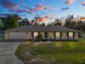 Single-story house with attached garage and brick accents, at dusk at 7101 Scenic Pl, Lakeland, FL 33810