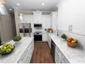 Modern kitchen featuring white cabinetry, granite counters, and stainless steel appliances at 715 Teaberry Trl, Polk City, FL 33868
