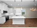 White kitchen with granite countertops and stainless steel appliances at 715 Teaberry Trl, Polk City, FL 33868