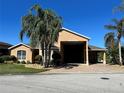 Inviting single-story home featuring a large portico, side garage, and manicured front yard at 1015 Crossroads Dr, Polk City, FL 33868