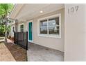 Welcoming front porch with teal door and black metal railing at 107 W 7Th St, Frostproof, FL 33843
