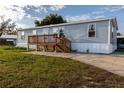 Single-wide mobile home with wood deck and steps at 1126 Lakewood W Cir, Lakeland, FL 33801