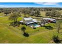 Aerial view of a home, pool, barn and expansive green space at 1722 Broken Arrow N Trl, Lakeland, FL 33813