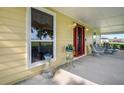 Farmhouse front porch with vintage wicker furniture and potted plants at 1722 Broken Arrow N Trl, Lakeland, FL 33813
