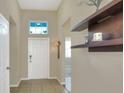 Bright entry hall with tiled floor, neutral walls, and floating shelves at 3710 Madbury Cir, Lakeland, FL 33810