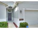 Front entry with gray door, wreath, and adjacent garage at 3710 Madbury Cir, Lakeland, FL 33810