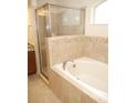Elegant bathroom with a soaking tub and a separate glass-enclosed shower with tile surround and granite counters at 4018 Sundance Place Loop, Mulberry, FL 33860