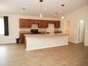 Modern kitchen featuring granite countertops, wood cabinets, and stainless steel appliances with an open floor plan at 4018 Sundance Place Loop, Mulberry, FL 33860