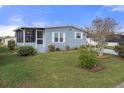 Quaint manufactured home with a well-manicured lawn and shrubs at 5079 Lodgewood Dr, Lakeland, FL 33810