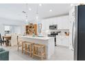 Modern kitchen with white cabinets, stainless steel appliances, and an island at 636 Trotters Dr, Eagle Lake, FL 33839