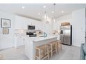Modern kitchen with white cabinets, stainless steel appliances, and an island at 636 Trotters Dr, Eagle Lake, FL 33839
