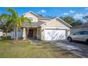House exterior featuring a two-car garage and front yard at 8309 Porch Ct, Lakeland, FL 33810
