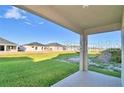 View from covered patio shows neighboring houses and yard at 1509 Leamington Ln, Winter Haven, FL 33884