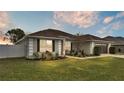 House exterior at dusk, showcasing landscaping and garage at 1570 Doves View Cir, Auburndale, FL 33823