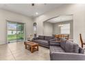 Spacious living room with tiled floors, gray couches, and access to a patio at 2507 Torrens Dr, Lakeland, FL 33805