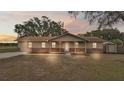 Attractive home exterior at dusk, features a shed and yard at 27 Moss E Rd, Auburndale, FL 33823