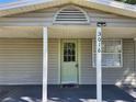 Welcoming front porch with a green door, white columns, and visible house number at 3016 Hutchins St, Eaton Park, FL 33840