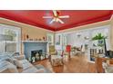 Cozy living room with hardwood floors, fireplace, and red accent ceiling at 316 8Th Ne St, Winter Haven, FL 33881