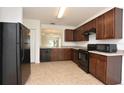 Spacious kitchen with dark wood cabinets, black appliances, and tile floor at 3648 Julius Estates Blvd, Winter Haven, FL 33881