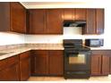 Dark wood cabinets, black appliances, and a view into the dining area at 3648 Julius Estates Blvd, Winter Haven, FL 33881