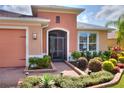 Inviting entryway with a screened-in porch and professionally landscaped flower beds at 453 Treviso Dr, Kissimmee, FL 34759