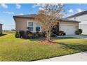 Tan house with landscaping and a two-car garage at 4710 Osprey Way, Winter Haven, FL 33881