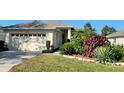 Charming home featuring a two-car garage, complemented by lush landscaping and a well-maintained lawn at 6555 Lake Clark Dr, Lakeland, FL 33813