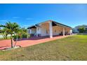 Single story home with covered carport and well-manicured lawn at 1039 Motorcoach Dr, Polk City, FL 33868