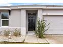 Front entrance with black door and small garden at 1405 Kissimmee Dr, Kissimmee, FL 34759