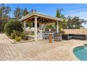 Covered outdoor kitchen and seating area with a fire pit at 1665 Blue Heron Ln, Lakeland, FL 33813