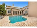 Freeform swimming pool with a stone patio and lounge chairs at 1665 Blue Heron Ln, Lakeland, FL 33813