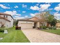 Tan house with a beige garage door and a brick paver driveway at 1832 Prima Vista Dr, Lakeland, FL 33810