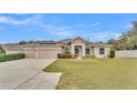 Tan house with solar panels, 2-car garage, and landscaped lawn at 212 Kissengen Park Dr, Bartow, FL 33830