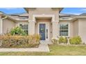 Home's front entrance with navy blue door and wreath at 212 Kissengen Park Dr, Bartow, FL 33830