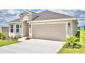 Newly built home with light beige siding, two-car garage, and driveway at 237 Piave St, Haines City, FL 33844